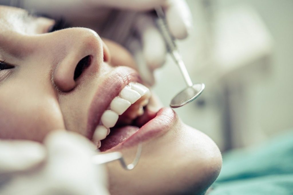A woman receiving dental cleaning at a dentist's office.